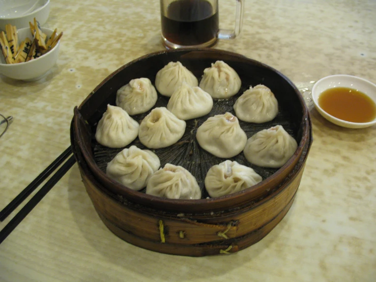 several dimins being cooked in a steamer with chopsticks