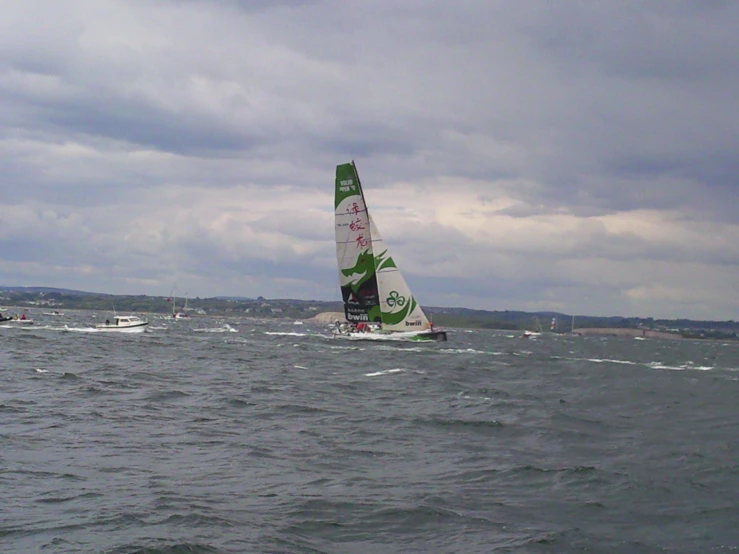 a sailboat with green sails in the ocean