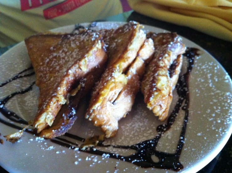 some kind of food on a white plate with syrup on top