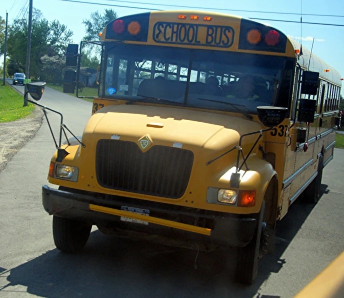 a school bus traveling down a street near some grass