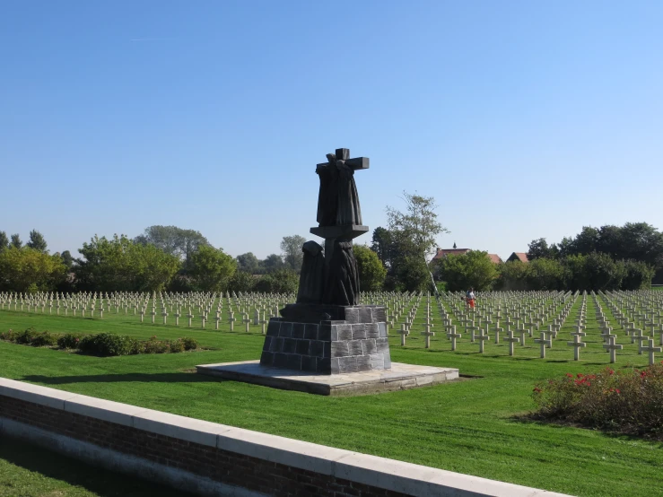 a large grave with an iron cross on it is sitting in the middle of an old cemetery