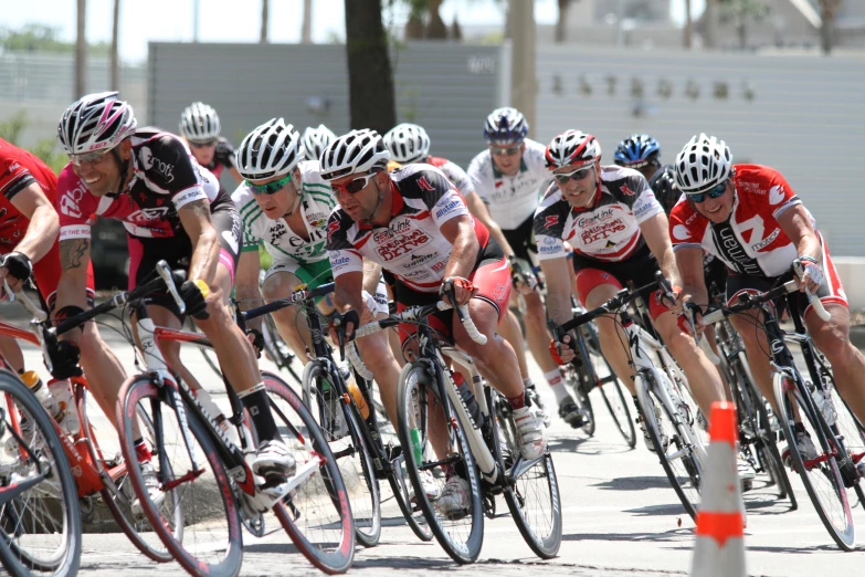 a bunch of cyclist are riding down the road