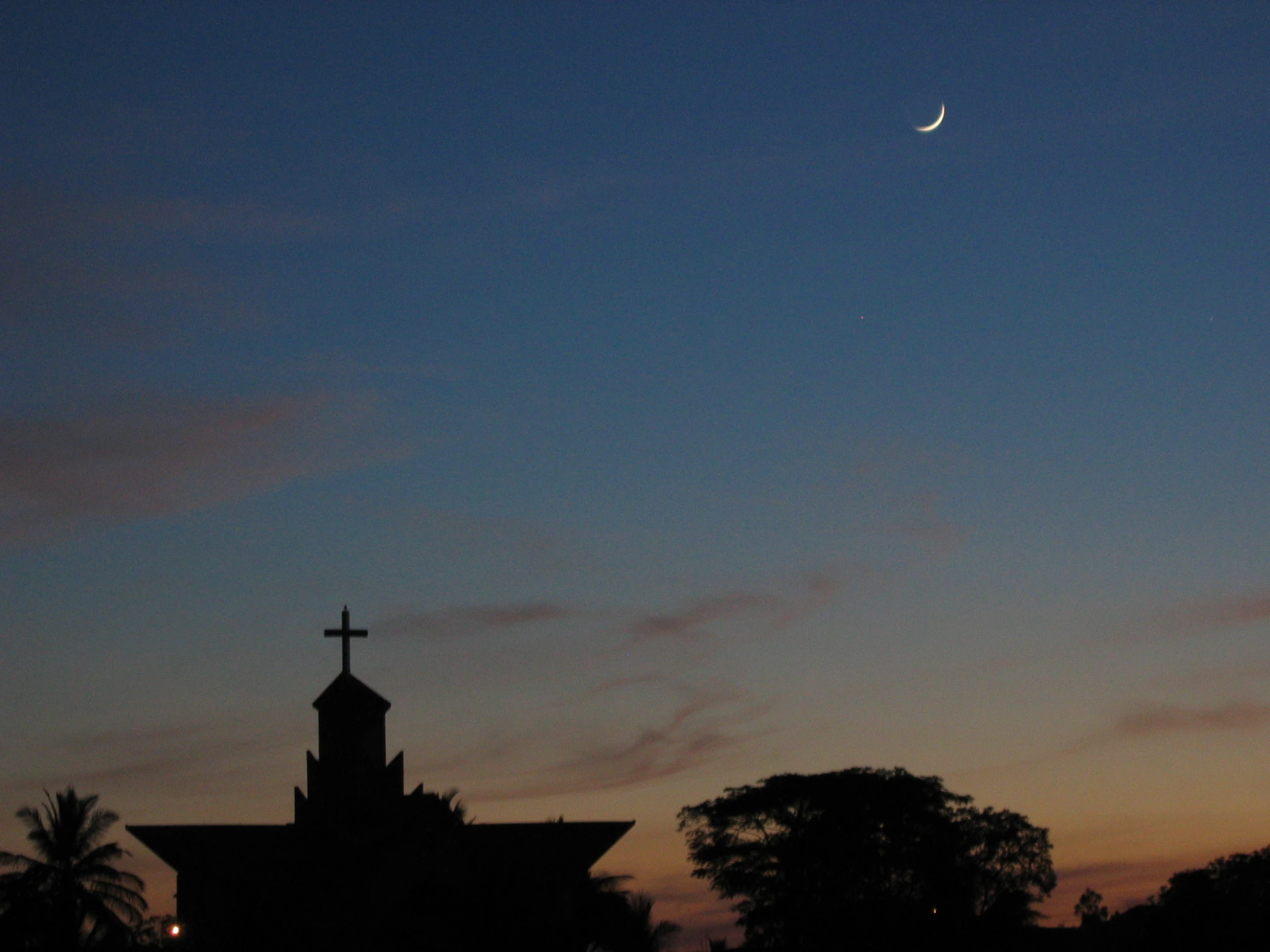 moon shining in the distance over an ornate church