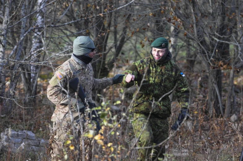 two guys who are talking in a forest