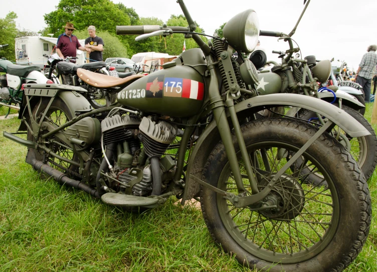 some vintage motorcycles parked in the grass