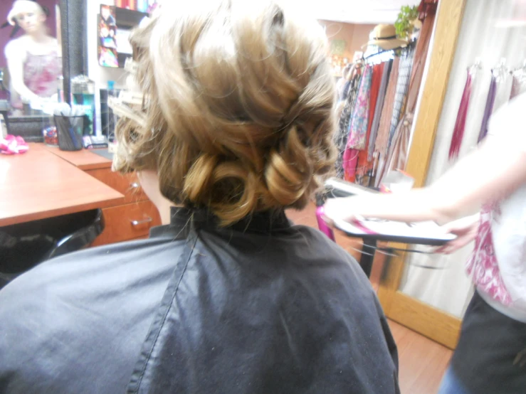 a person getting a haircut in front of a mirror