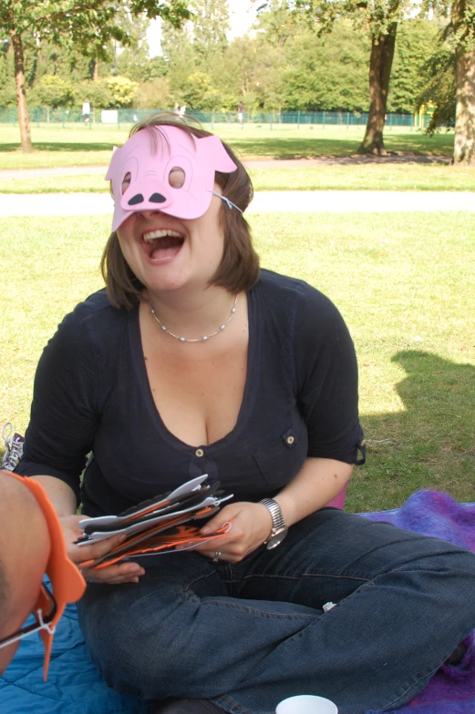 woman in black shirt on blanket with pink nose and newspaper