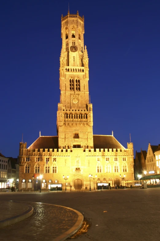 a lighted building with a clock tower in the middle