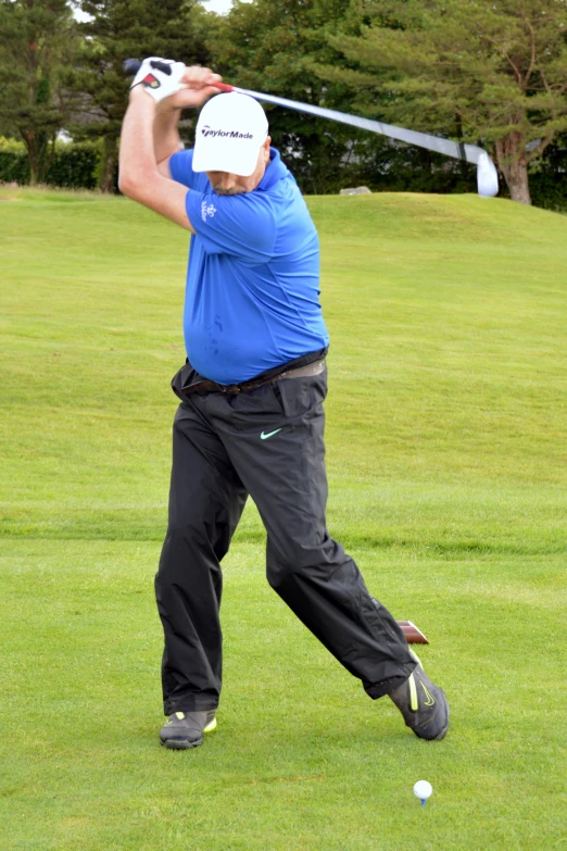 a man swings a golf club during a practice round