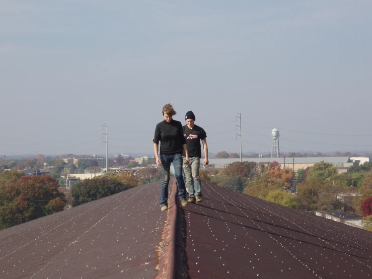two men who are walking on a roof