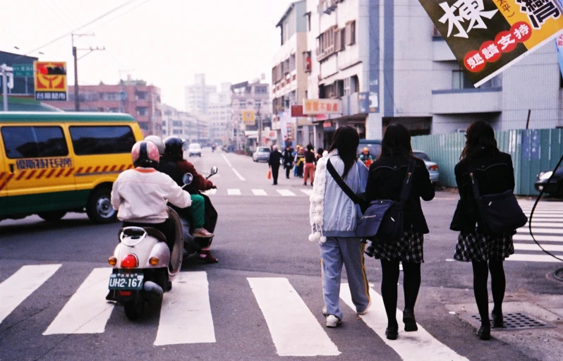 people walking across the street in a crosswalk