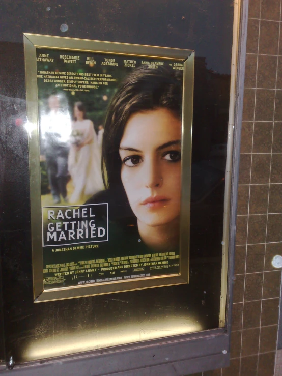 a poster for rachel martin hangs on the wall of a restroom
