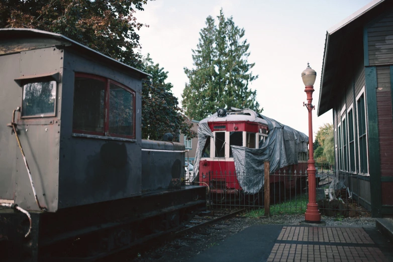 an old train is sitting on some tracks next to a building