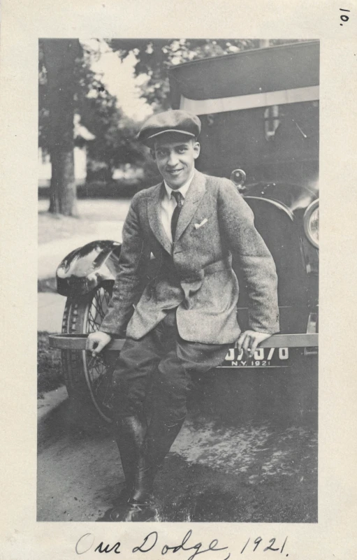 black and white pograph of man leaning on car