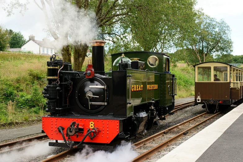 steam engine train pulling an old style cart down the tracks