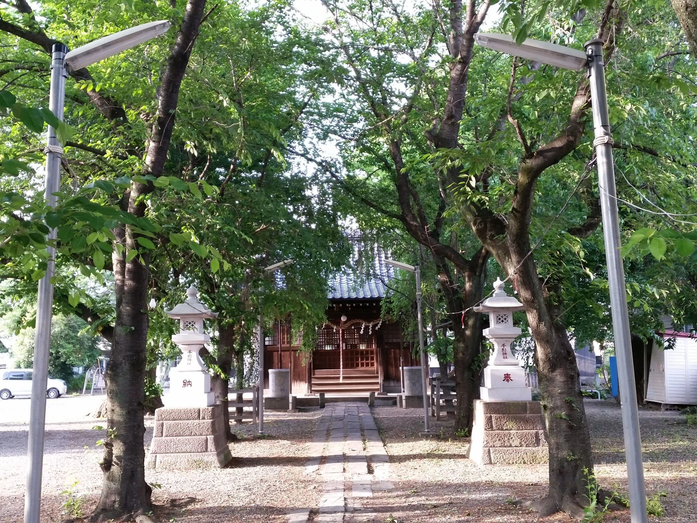 a small hut sitting under trees by the street