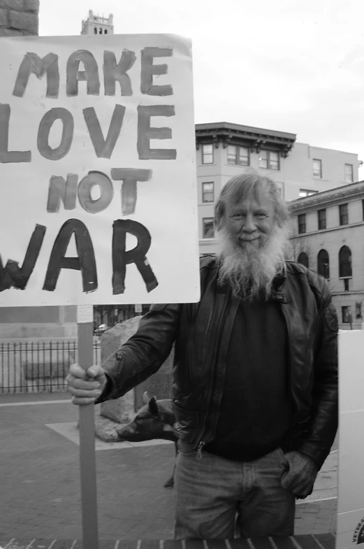 a man with a long white beard is holding a sign