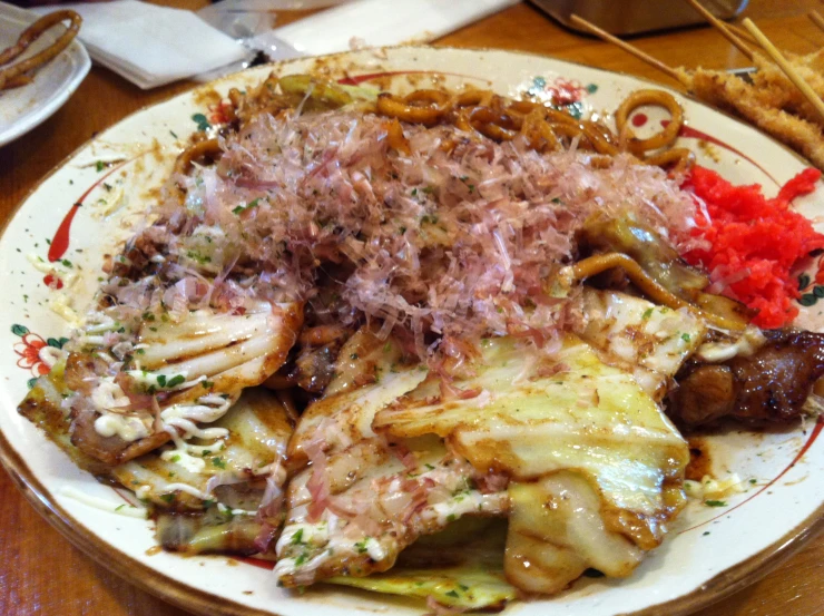 a plate of food has onions, pasta and other foods on it