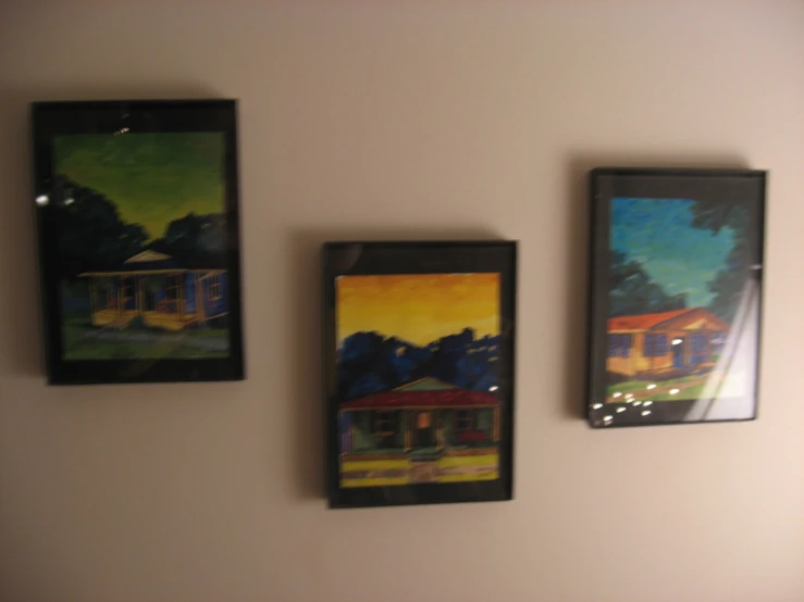 three paintings on a wall hang from the wall