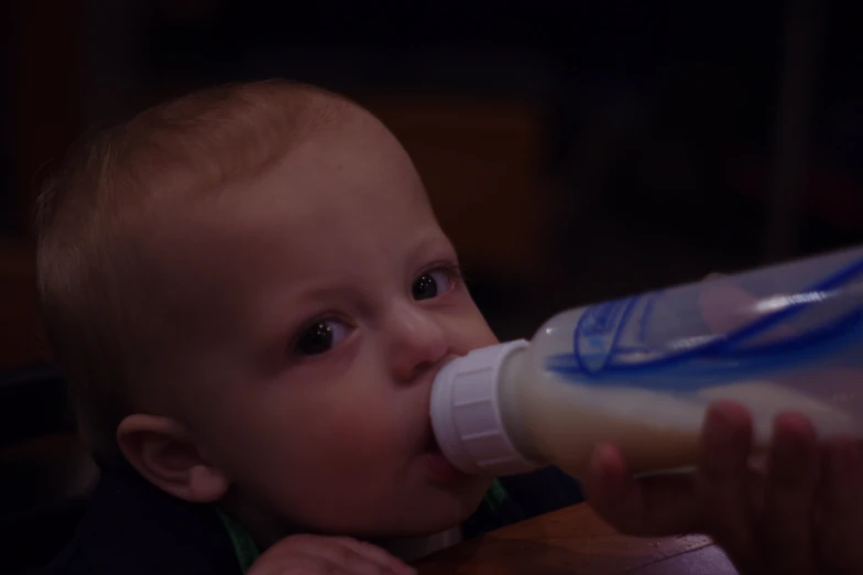 a baby eating a bottle of juice from it's mouth