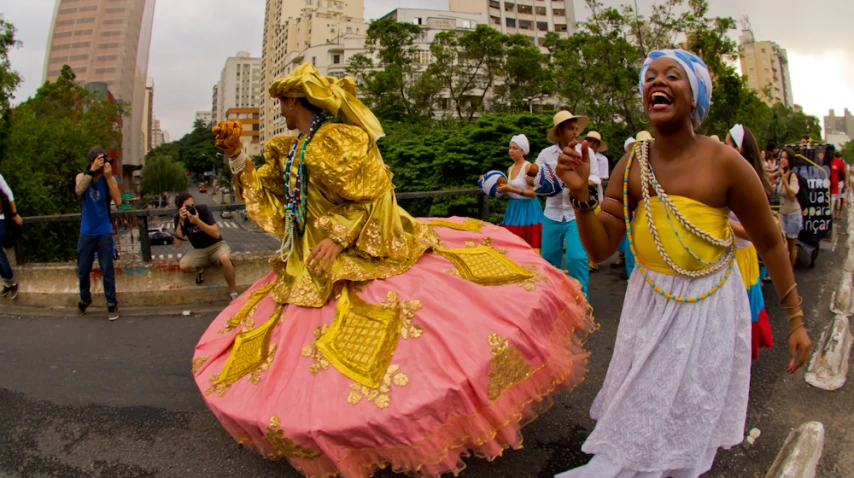 two women dressed in costume while a crowd watches