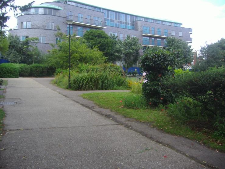 an empty sidewalk with tall building behind it