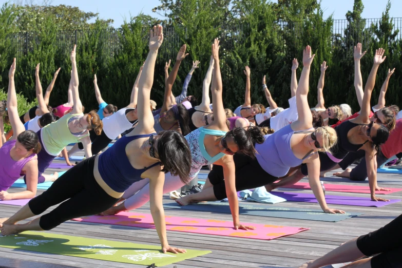 a group of people doing yoga outside with one person holding her head up