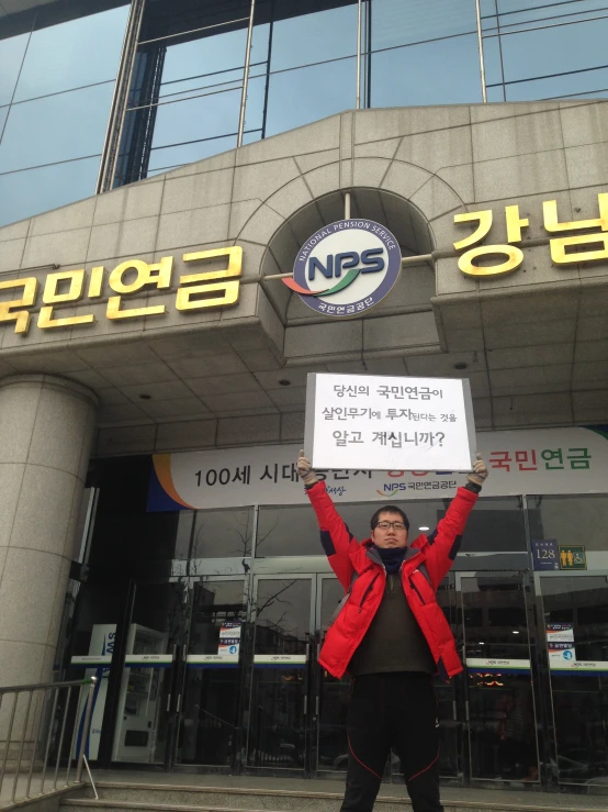 a person standing in front of a building holding a sign