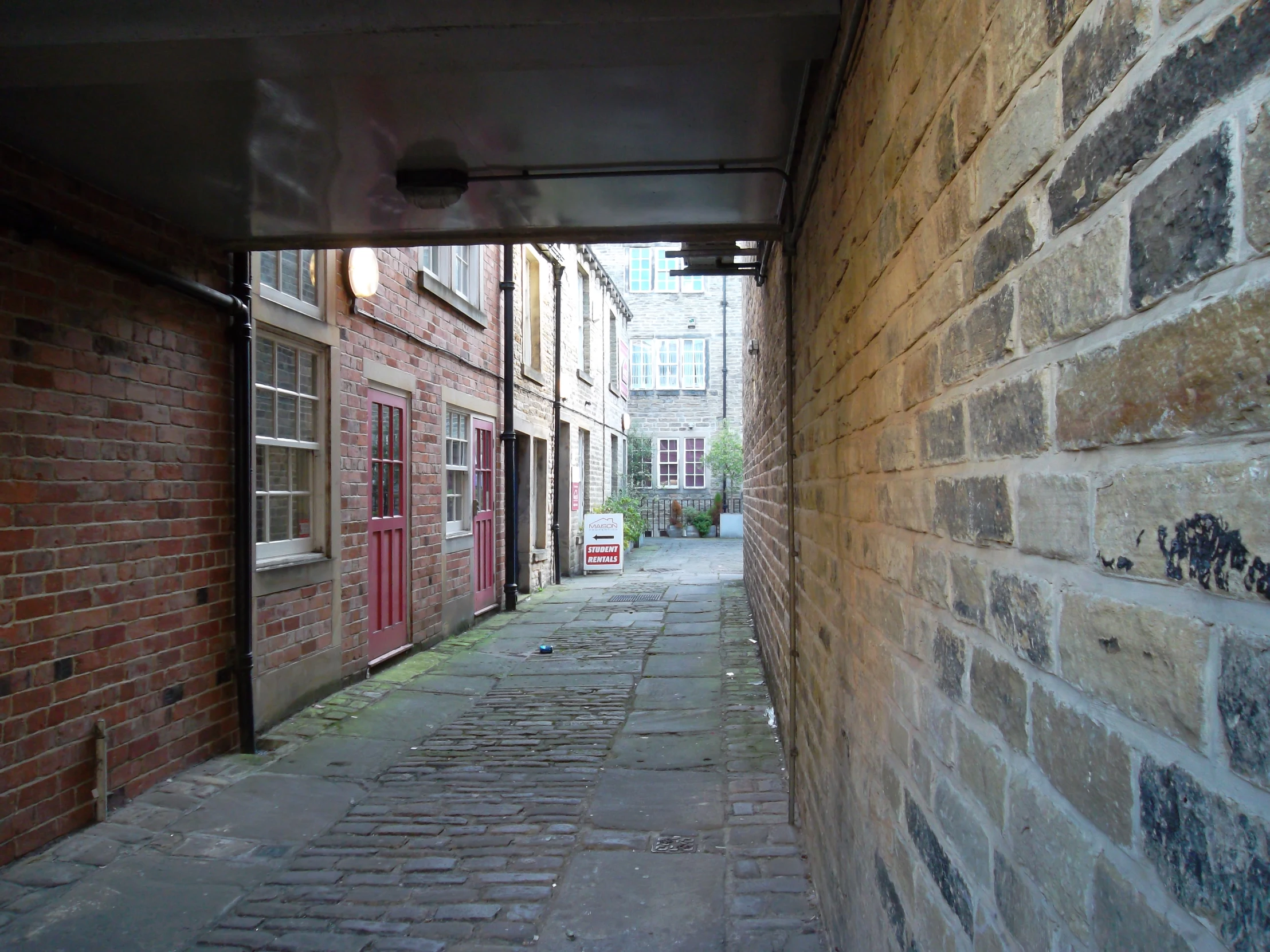 a brick alley way with a fire hydrant between two buildings