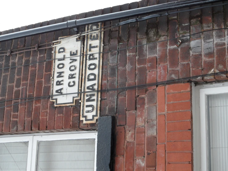 a white and black sign on a brick building