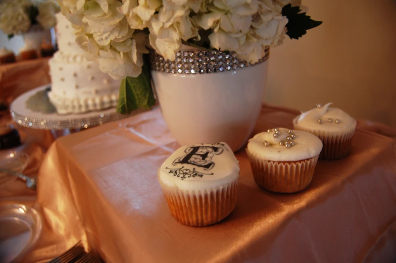 cupcakes and flowers on a table with a table cloth