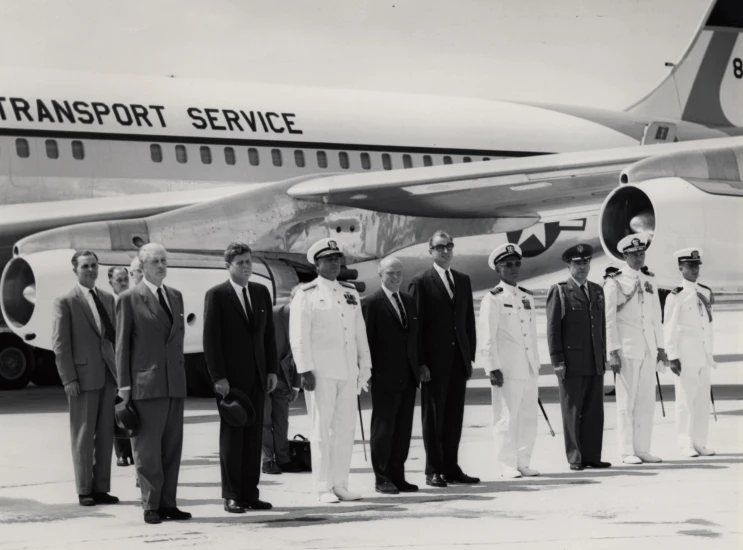 the men are standing in front of a large passenger airplane