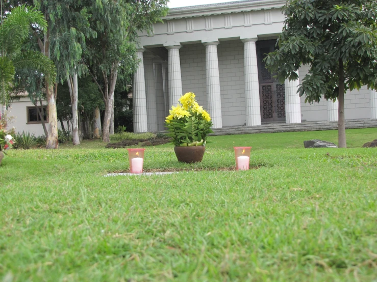 a large building with pillars and flowers in the lawn