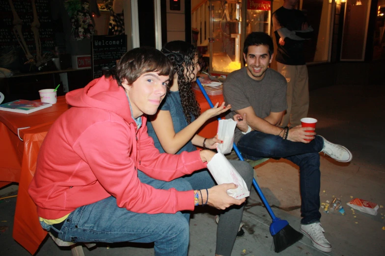 three young people with one holding a drink and the other on a boat