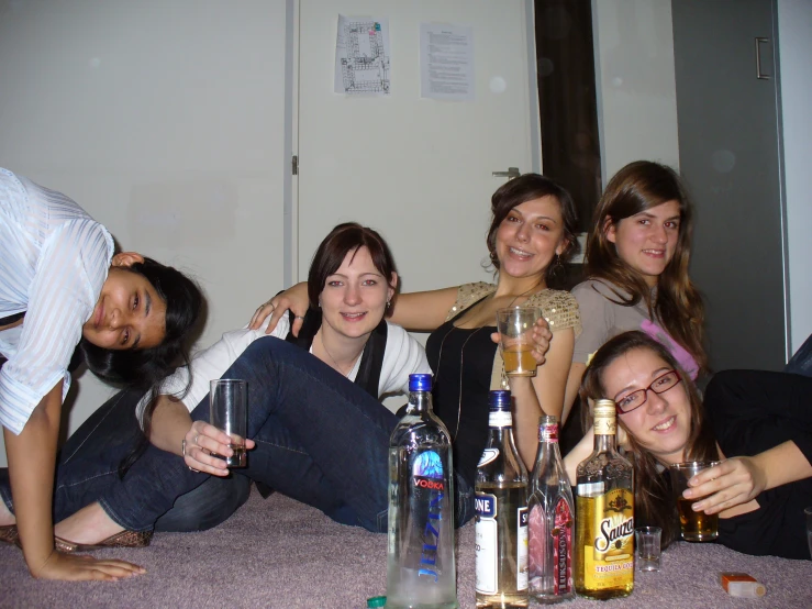 group of girls posing for po with bottles on floor