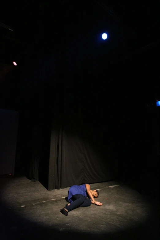 the man is laying on the floor on the stage