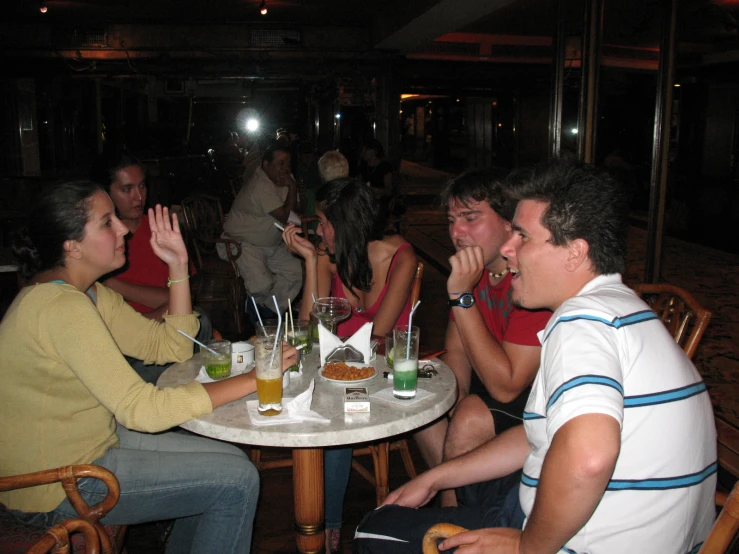 people sitting around a table and eating in the dark