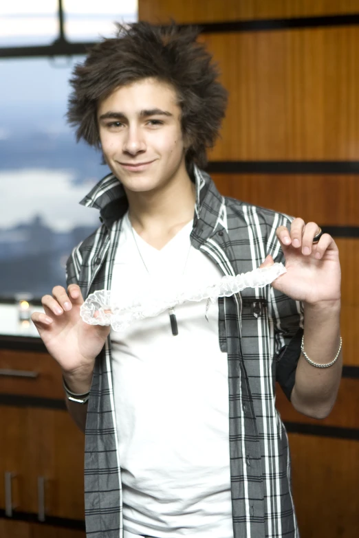 a boy holding some kind of string with a smile on his face