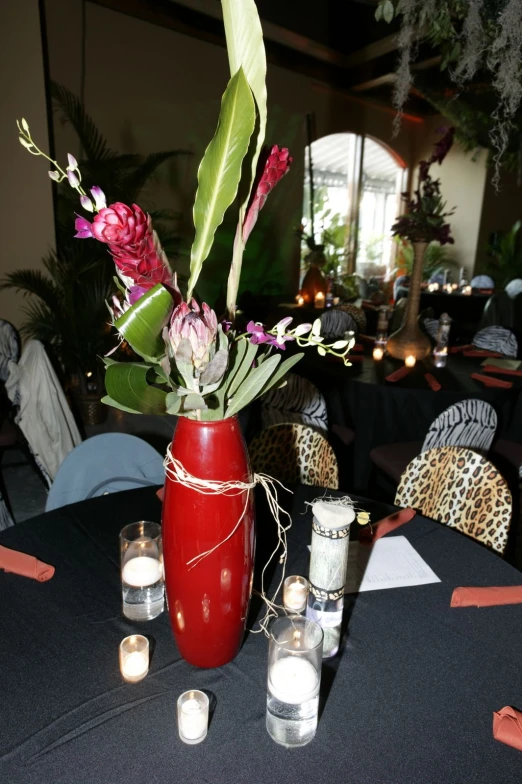 flowers are sitting in a vase with some lit candles