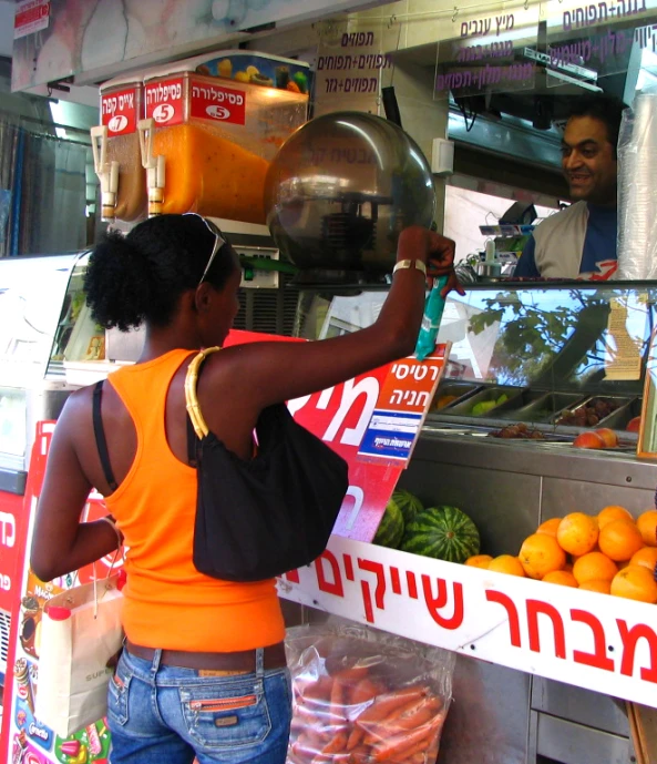 the woman is standing by the display of fruit