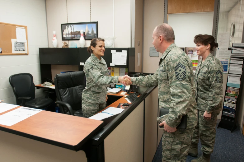 a woman shaking a mans hand with an office chair