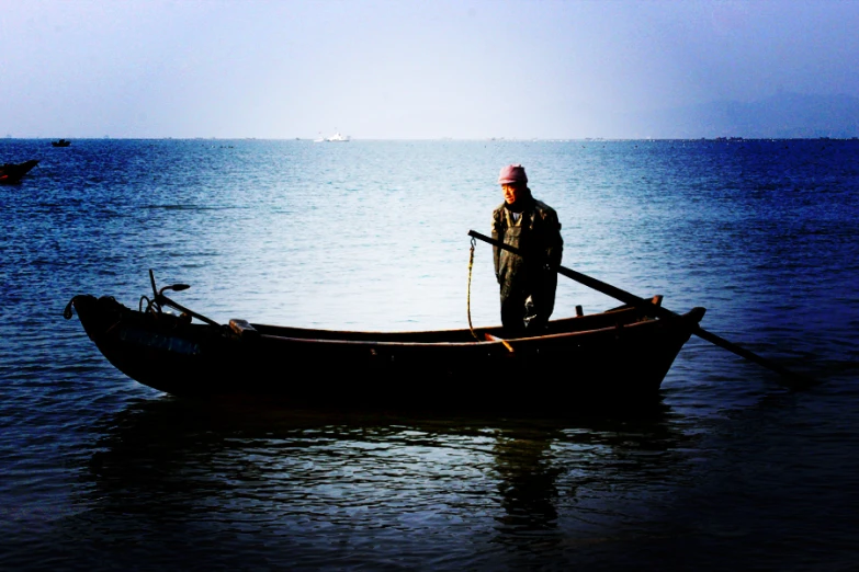 a man is standing on the bow of a boat