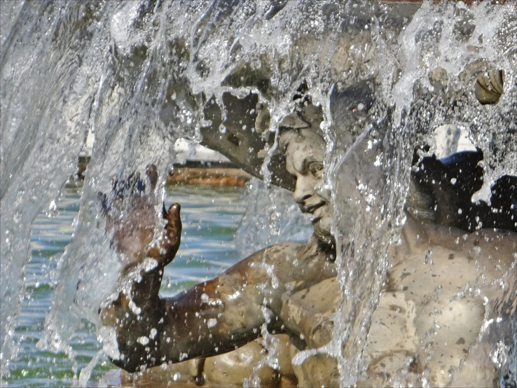 an elephant standing next to a statue in the water