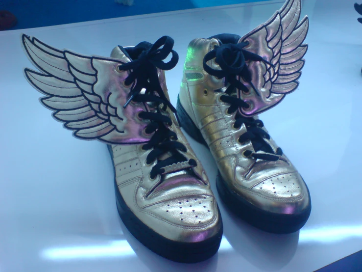 a pair of sneakers that has wings on the heel