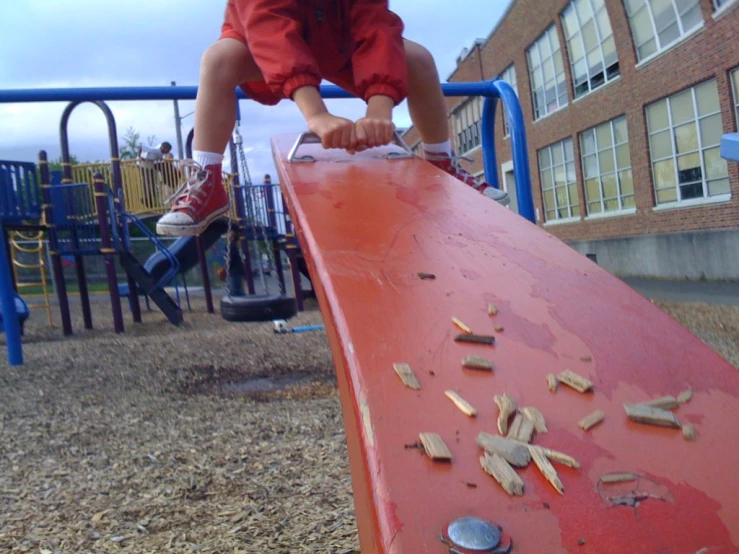 a child climbing on the top of a red slide