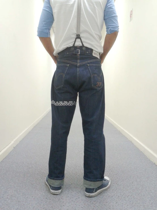 a man standing up in a hallway with his back to the camera