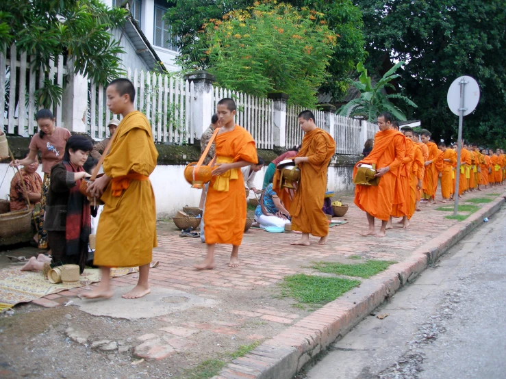 several buddhist monks standing and sitting on the steps