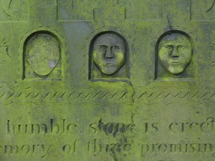 a statue depicting three faces of four people and one third woman