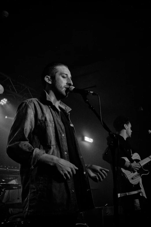 some guys on stage playing instruments and singing into microphones