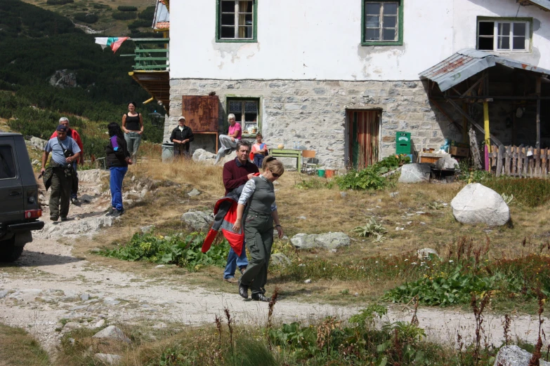 the people are walking down the hill to go camping